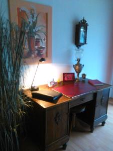 an office with a desk with a lamp on it at Ferienwohnung Rosentraum in Oberotterbach