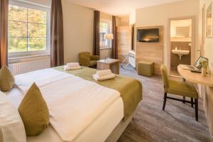 ein Hotelzimmer mit einem großen Bett und einem Bad in der Unterkunft Am Schloßbrunnen Bad Muskau in Bad Muskau