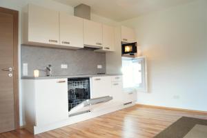 a kitchen with white cabinets and a sink at Ferienwohnung Familie Alt Rinn, Innsbruck in Rinn