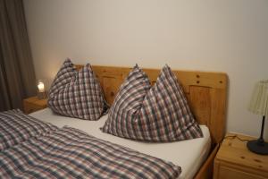 RinnにあるFerienwohnung am Bauernhof Familie Altのベッドの上に座った枕2つ