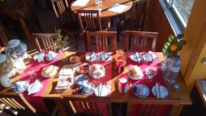 a table with a red table cloth with plates and dishes at SEIA Apartamento Vista SERRA in Seia +10 photos