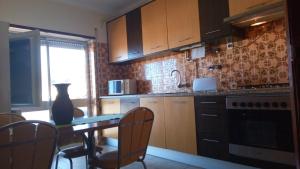 a kitchen with wooden cabinets and a table with chairs at SEIA Apartamento Vista SERRA in Seia