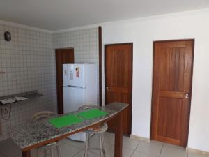 a kitchen with a counter and a white refrigerator at Pousada Restinga Apart Service- Aeroporto in Lauro de Freitas