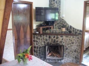 a living room with a tv and a fireplace at Chalés Vale Verde in Visconde De Maua
