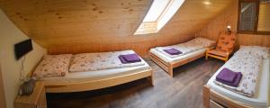 ズノイモにあるPenzion Sklep Sv. Urbanaの木造キャビン内のベッド2台が備わる部屋