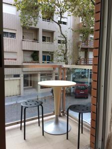 a table and two stools in front of a window at Casa do Tio - Matosinhos Praia in Matosinhos