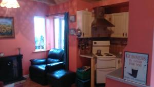 a kitchen with a stove and a chair in a room at Cosy Lakeside Cottage John's hollow in Headford
