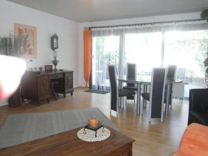 a living room with a table and a dining room at Ferienwohnung Rosentraum in Oberotterbach