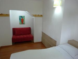 a bedroom with a red chair and a bed at Casa Jade in Rionegro