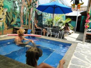 dos niños jugando en una piscina en un complejo en Hostal Mochilas, en Granada
