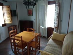 sala de estar con mesa y sofá en Apartamentos Asador De La Plaza Vieja, en Cazorla