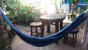 a hammock with a table and two stools and a table at Hostal Mochilas in Granada