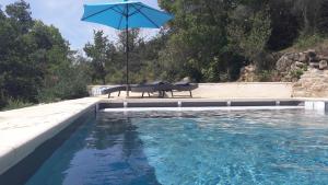 a blue umbrella sitting next to a swimming pool at Chemin Du Soula in Couiza