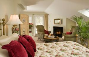 ein Schlafzimmer mit einem Bett und ein Wohnzimmer mit einem Kamin in der Unterkunft Hydrangea House Inn in Newport