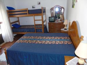 a bedroom with two bunk beds and a dresser at Alojamento Local Céu-Azul in Porto de Mós