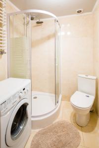 a bathroom with a washing machine and a toilet at Bright and cozy apart with balcony in Lviv