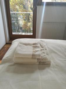 een bed met twee handdoeken en een raam bij Apartament Sea&Sun in Świnoujście
