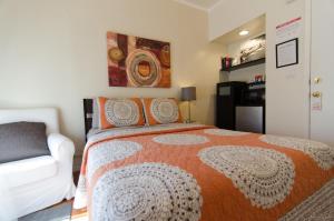 1 dormitorio con 1 cama grande y 1 sofá blanco en Hotel Royal, en Long Beach