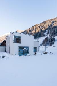 ein weißes Haus mit einem Berg im Hintergrund in der Unterkunft Laudinella - Apart in See