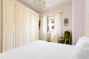 1 dormitorio con cama blanca y lámpara de araña en Crystal House, en Roma