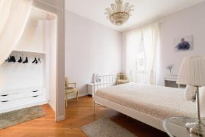 a white bedroom with a bed and a chandelier at Crystal House in Rome