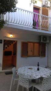 a white table and chairs in front of a building at Apartman Restović in Bol