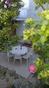 Una mesa y sillas blancas en un jardín. en Apartman Restović, en Bol