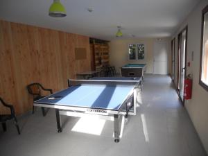 a ping pong table in the middle of a room at Auberge du Saut des Cuves in Xonrupt-Longemer