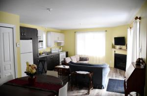 ein Wohnzimmer mit Sofa und eine Küche in der Unterkunft Chalet Versailles in Saint Come