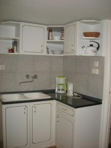 a kitchen with white cabinets and a counter top at Haus Jeremias therme in Zalakaros +94 photos