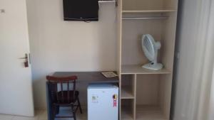 a small kitchen with a desk and a refrigerator at Pousada Villa Branca - Petar (Apiaí-SP) in Apiaí