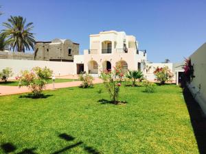 a house with a lawn in front of it at Villa Tezdain in Houmt Souk