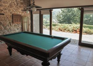 una mesa de billar en una habitación con suelo de baldosa en Quinta de Albergaria en Facha