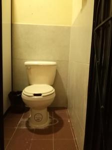 a bathroom with a white toilet in a stall at Hostal San Pueblo in Oaxaca City