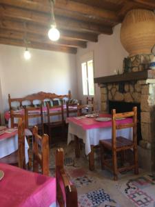 a dining room with tables and chairs and a fireplace at Hostal Ribera de Salobre in Salobre