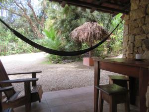 a hammock in a room with a table and chairs at Casas Mal Pais in Mal País