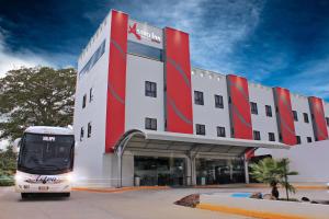 Ein Bus steht vor einem Gebäude. in der Unterkunft Astro Inn Hotel Express in Xalapa