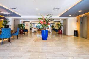 a lobby with a large blue vase with plants in it at VIVE Hotel Waikiki in Honolulu