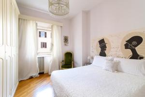 1 dormitorio con cama blanca y lámpara de araña en Crystal House, en Roma