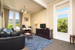 uma sala de estar com um sofá, uma mesa e uma janela em Sennen House Boutique Accommodation em Picton