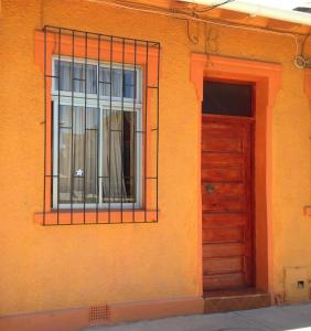un edificio naranja con puerta y ventana en Casa Barros Borgoño, en Valparaíso