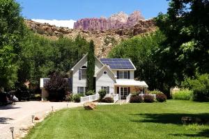 a house with a solar roof with mountains in the background at 2 Cranes Inn - Zion in Rockville