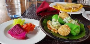 una mesa con dos platos de comida en una mesa en Rumah Dharma 2 Riverside, en Borobudur
