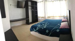 a bedroom with a bed with a blue comforter at El Arrayan in Valle de Bravo