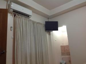 a room with a curtain and a television on the ceiling at Cliff Side Beach Resort and Cottages in Lomangcapan