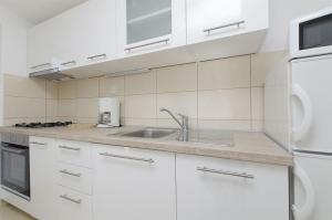 een keuken met witte kasten en een spoelbak bij Apartment Josipa in Primošten