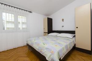 een witte slaapkamer met een bed en een raam bij Apartment Josipa in Primošten