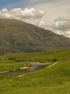 a river in a field with a mountain in the background at Park Guest House in Inverness +18 photos