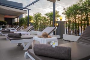 a row of lounge chairs with hats on them on a patio at Baan Nilrath Hotel - SHA Extra Plus in Hua Hin