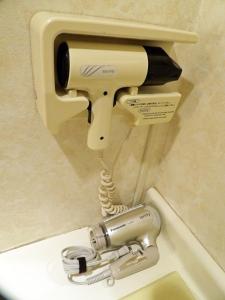 a hair dryer attached to a toilet in a bathroom at Southern Cross Inn Matsumoto in Matsumoto